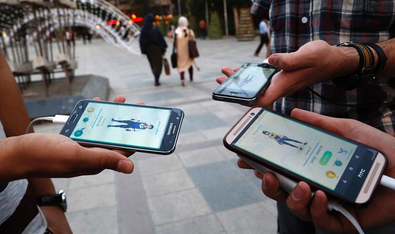 موضوع آنقدر جدی است که پلیس استرالیا در پیامی عمومی از مردم درخواست میکند: «به خانواده خودتان اطلاع دهید که کجا میروید و چه موقع به خانه باز خواهید گشت.» و هشدار میدهد اینکه بگویید که در حال جمعآوری پوکمون بودهاید، دلیل موجهای برای ورود بیاجازه به یک محوطه یا ساختمان نیست. اگر از این بازی در مکانی عمومی استفاده میکنید، به اطراف خود توجه کنید. کشورهای حاشیه خلیج فارس نظیر کویت و امارات در خصوص استفاده از این بازی در برخی مناطق حساس هشدار جدی میدهند: «هیچ بهانهای برای عبور از قانون وجود ندارد.» این بازی از جیپیاس و دوربین گوشی کاربران استفاده میکند و همین نکته برای سازمان تنظیم مقررات ارتباطات امارات کافی بود تا به طور جدی در خصوص «نقض حریم خصوصی کاربران» هشدار دهد. مدتها بود که کاربران تلفنهای همراه، تا این حد غافلگیر نشده بودند؛ شاید از زمان ارائه اولین آیفون توسط شرکت اپل تا به امروز. آنها سالها با وضعیت کسالتباری مواجه بودند؛ گوشیهایی که هیچ حرف جدیدی برای گفتن نداشتند و تجربه تازهای ارائه نمیکردند. اما پوکمونگو معادلات را به هم زد. حالا کاربران به جای اینکه در خانه بنشینند و ساعتها با سایر کابران از طریق بازیهایی نظیر Clash of Clans یا نرمافزارهایی مثل فیسبوک، توییتر، اینستاگرام و نظایرشان تعامل داشته باشند، میتوانند وارد دنیای واقعی شوند. اگر پیش از این درون دنیای مجازی به دنبال یافتن دستاوردهای مجازی بودند، حالا این امکان را پیدا کردهاند که در دنیای واقعی به دنبال این دستاوردهای مجازی باشند. این امکان عجیبی است و دقیقاً همان تجربه جدیدی است که کاربران نیاز داشتند. با همه جنبههای مثبت* و منفی این بازی، به عقیده من پوکمونگو سرعت نزدیک شدن به نقطه تحول جدید در استفاده از ابزارهای همراه را افزایش داده است و باید آماده باشیم تا وارد عصر جدید ابزارهای همراه شویم. عصری که شاید بتوان آن را عصر «پساگوشی» نامید؛ به طوری که دیگر نیاز به گوشیهای تلفن همراه به گونهای که اکنون میشناسیم، نخواهیم داشت. شاید در آینده دستگاههای مشابه تلفنهای هوشمند امروزی در اختیار داشته باشیم که به جای نمایشگر، به عینک واقعیت افزوده (AR) مجهز هستند. اگر چنین اتفاقی رخ دهد، سبک جدیدی از زندگی پیش روی ما خواهد بود. اما هنوز مطمئن نیستم که آیا برای زندگی در چنین دورهای آماده هستیم یا خیر؟ آمادگی نداشتن برای چنین دورهای، خطرات زیادی برای ما به دنبال خواهد داشت و این، تاوان سنگینی دارد. نکتهای که با نگاه به بازی پوکمونگو توجه من را جلب میکند و البته موضوع جدیدی نیست، این است که شکار چیست و شکارچی کیست؟ کاربران شکارچیان پوکمون هستند و در عین حال، خودشان شکار شکارچیان دیگر خواهند شد؛ شکارچیانی که دادهها، تصاویر مکانها و رفتار جماعتی را رصد میکنند و اگر این شکارچیان، پایبند به اصول اخلاقی نباشند، بر سر این دادهها معامله خواهند کرد. باید منتظر بود و گوش به زنگ؛ هیچ پدیدهای حتی پوکمونگو را نباید دستکم گرفت. * چندی پیش گزارشی درباره تأثیر مثبت بازی پوکمونگو بر کودکان مبتلا به اوتیسم منتشر شد.